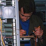 Kevin McMahon installing cabling for telephone exchange equipment.
